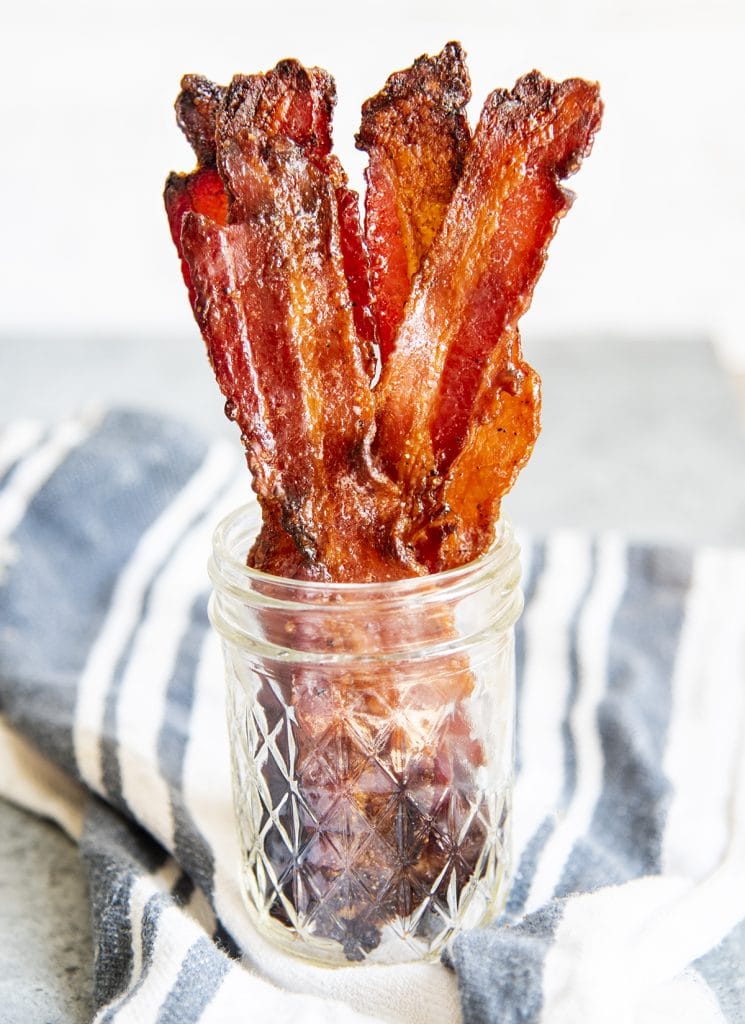 A small glass jar full of brown sugar bacon strips.
