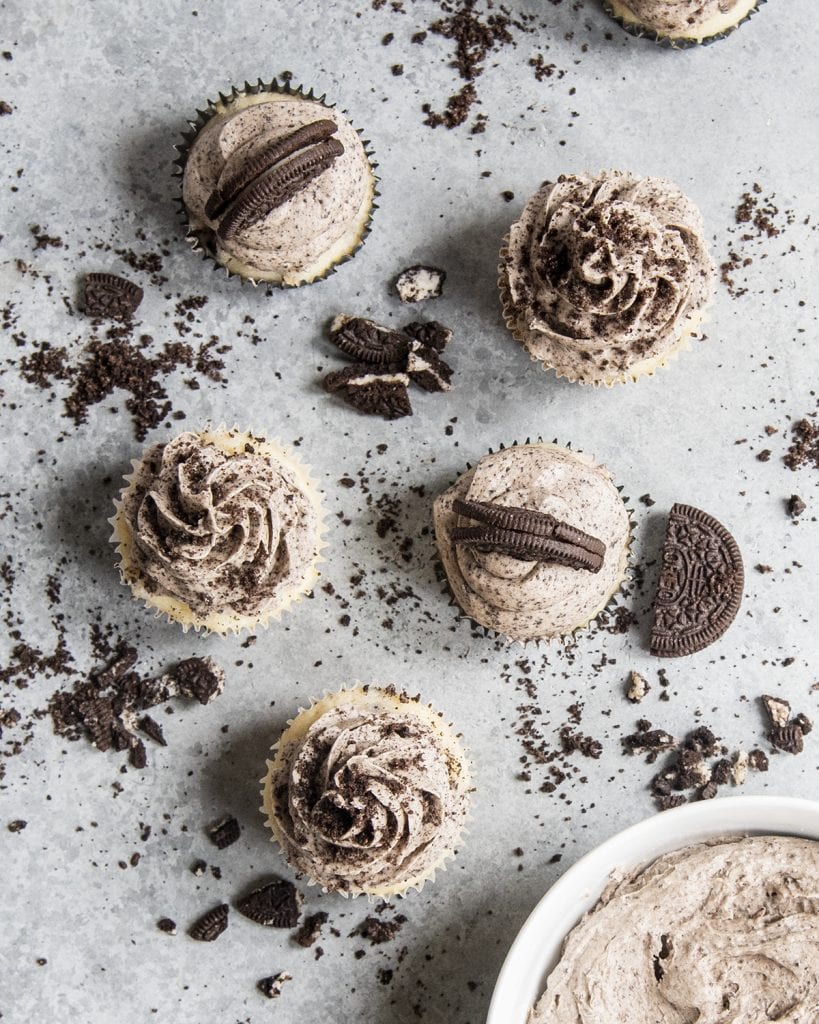 An overhead of 5 cupcakes topped with Oreo frosting, and Oreo crumbs.