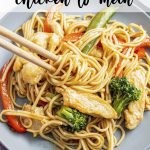 An overhead photo of a plate of chicken lo mein with vegetables with chopsticks wrapping up some of the noodles, with a text overlay for pinterest.