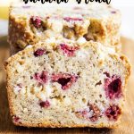 A slice of banana bread with raspberries and white chocolate chips, with a text overlay for pinterest.