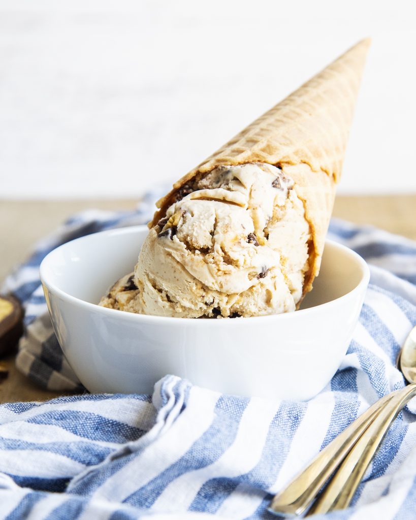A bowl of graham cracker ice cream, with an ice cream cone of it on top.