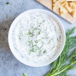 A bowl of homemade tzatziki sauce topped with fresh dil.