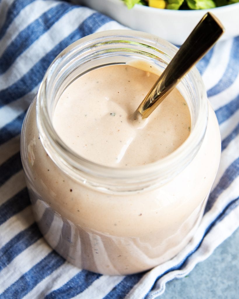 A jar of BBQ Ranch Dressing with a spoon in it.
