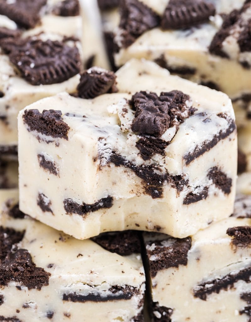 A close up of a piece of White chocolate cookies and cream fudge with a bite out of it.