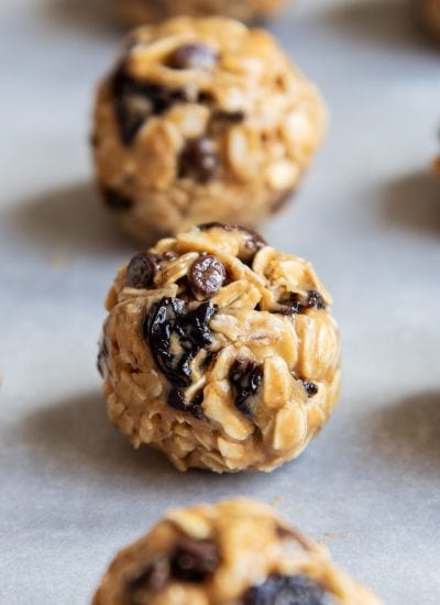 A tart cherry energy ball in a row on a piece of parchment paper.