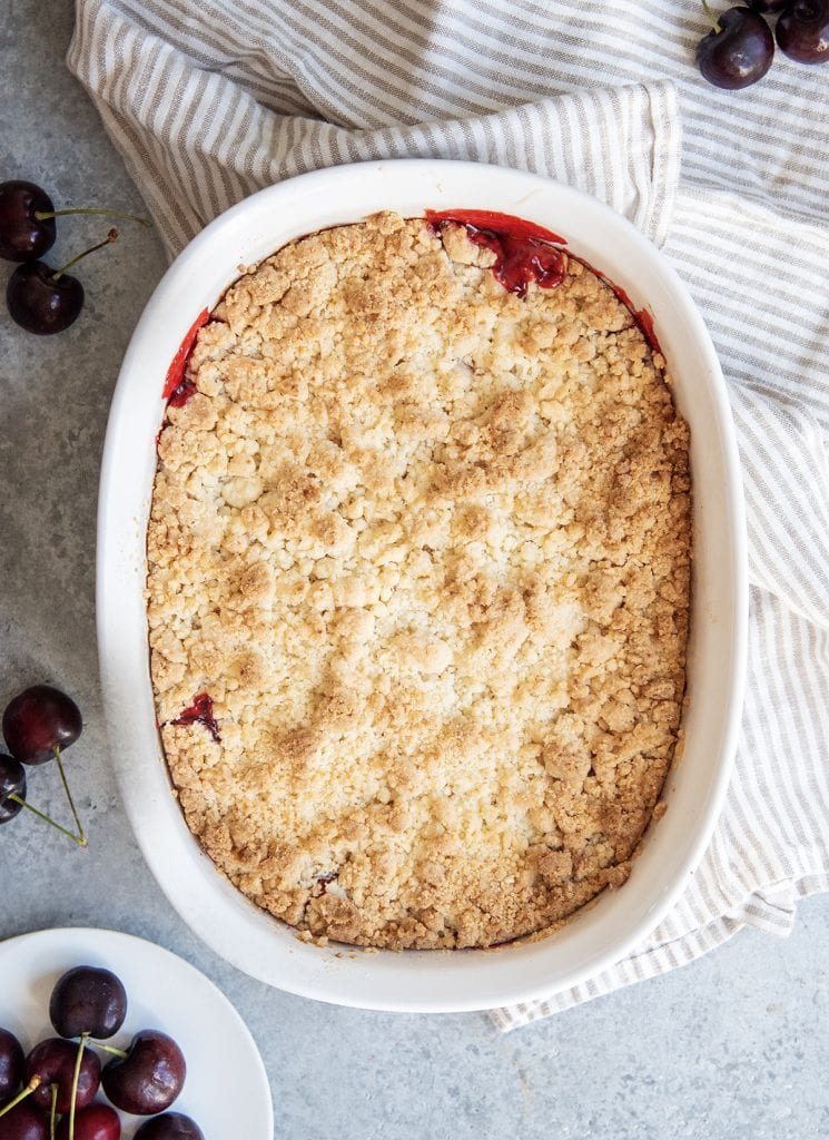 An overhead photo of a three ingredient cherry cobbler in a white baking pan.