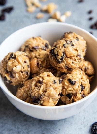 A white bowl full of cherry and oat energy balls.