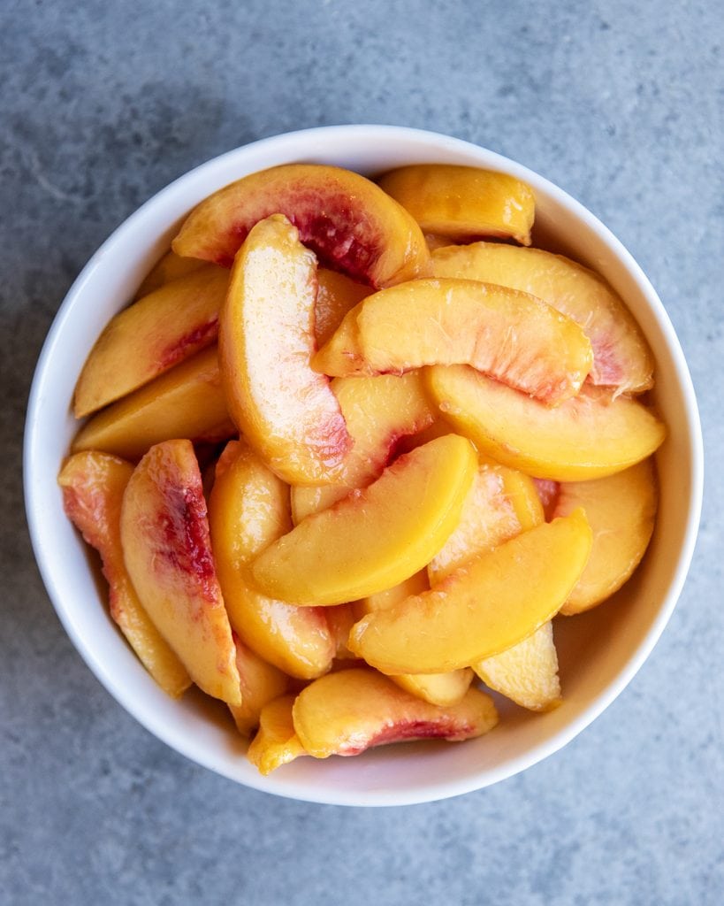 A bowl of peeled, and sliced peaches.