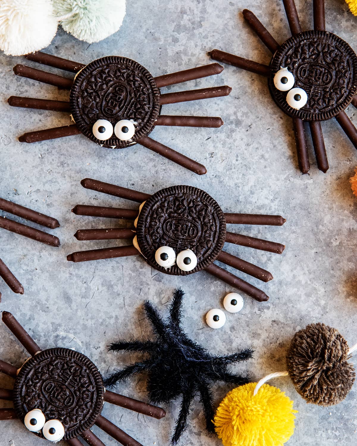 Oreo spiders made with Oreos topped with 2 candy eyes, and 4 chocolate Pocky stick legs on each side.