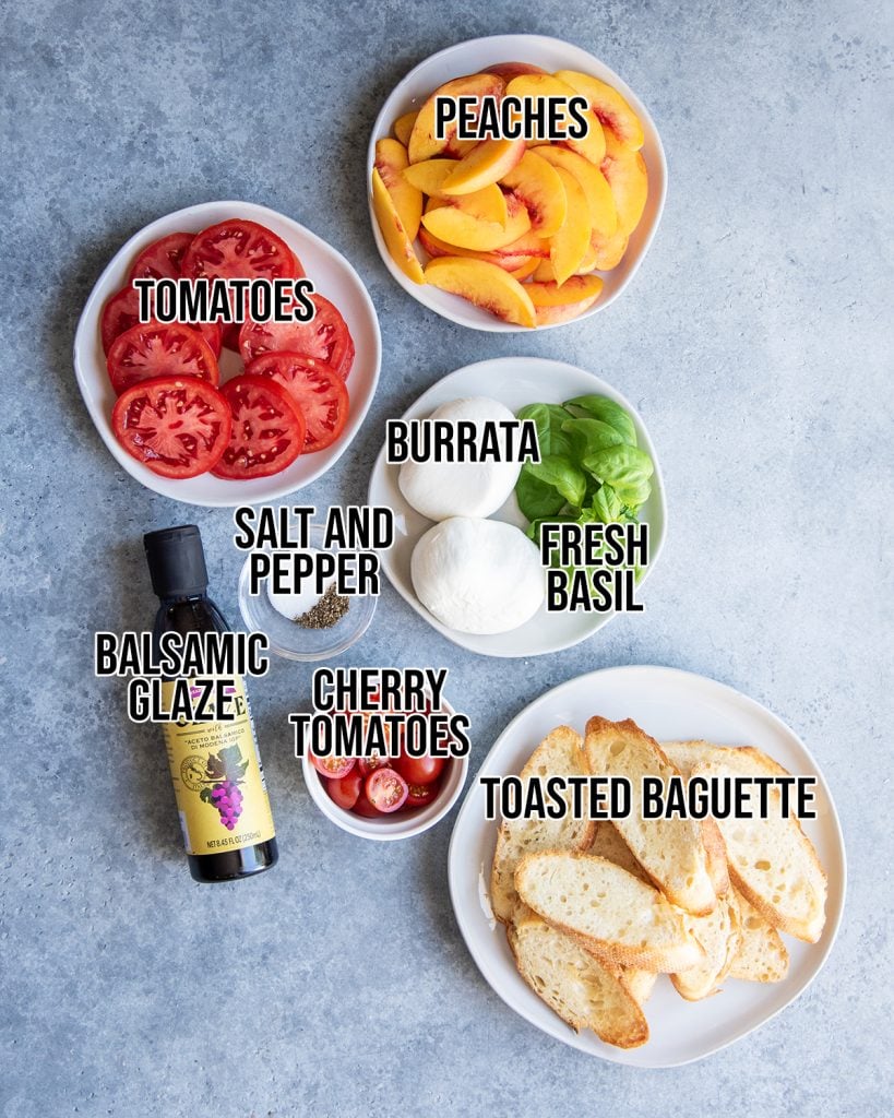 An overhead photo of the ingredients needed to make a tomato and peach burrata salad.