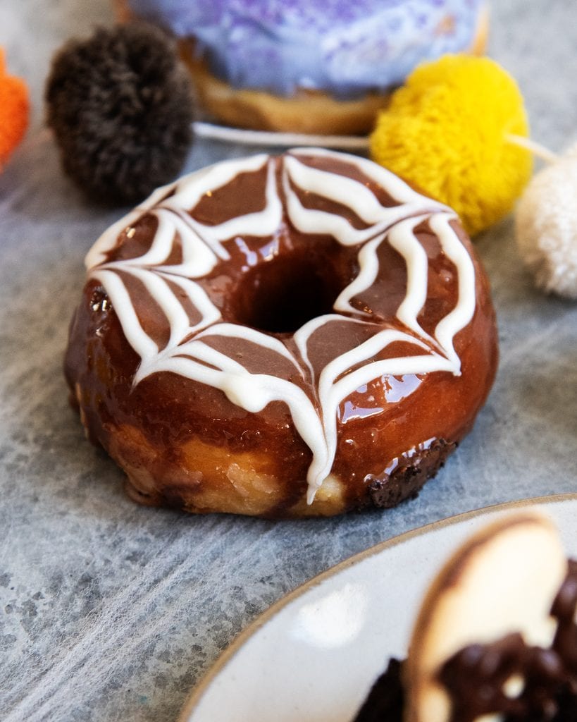 A chocolate spider web decorated donut.