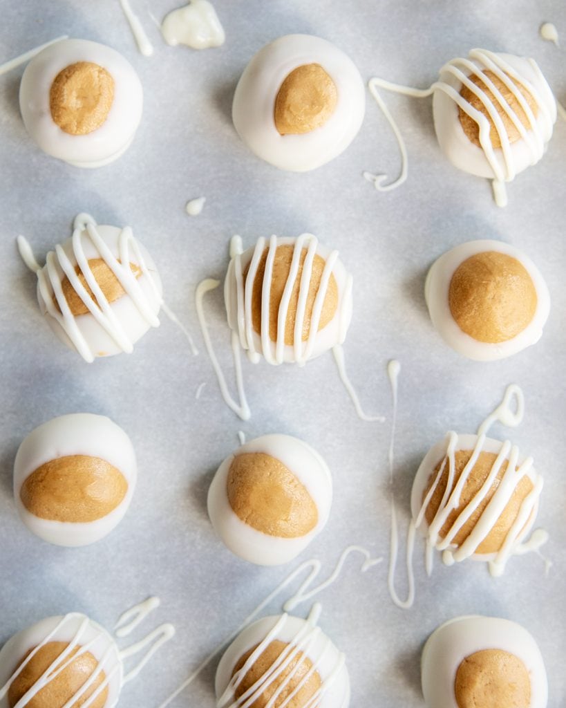 An overhead photo of Biscoff Buckeye Balls in rows, drizzled with extra white chocolate.