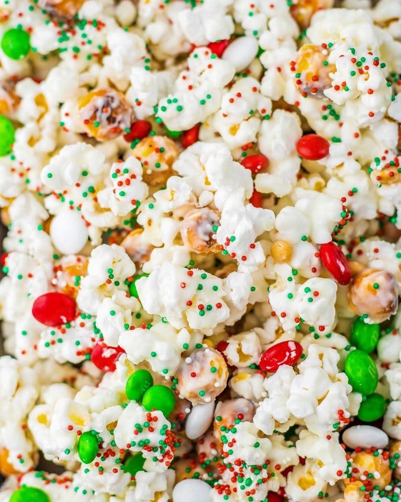 A close up of a pile of white chocolate Christmas popcorn with m&ms.