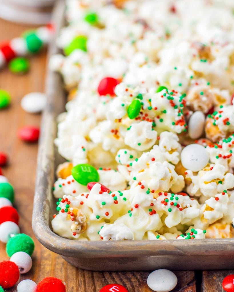 A close up of a pan of white chocolate popcorn with Christmas sprinkles.