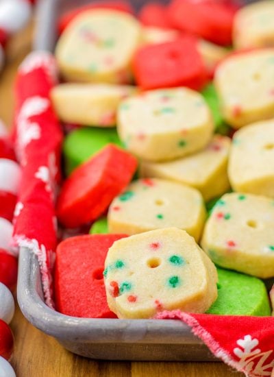 A tray of Christmas shortbread cookies, they are holiday colored, red, green, and white with sprinkles.