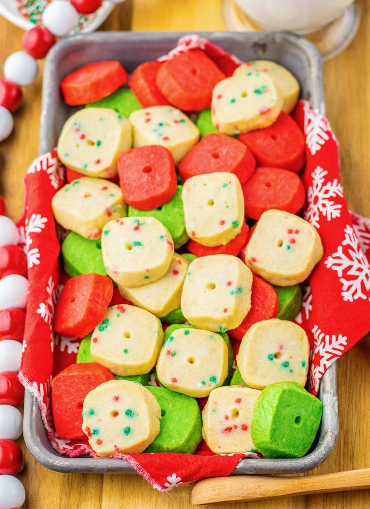 A pan of mini Christmas shortbread cookies. They are Christmas colored, red, white, and green.