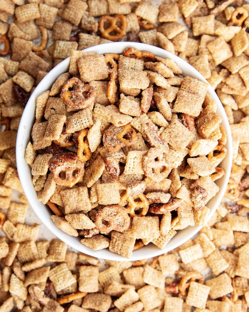 An overhead photo of a bowl of chex mix with chex cereal, mini pretzels, and pecans coated in cinnamon sugar.