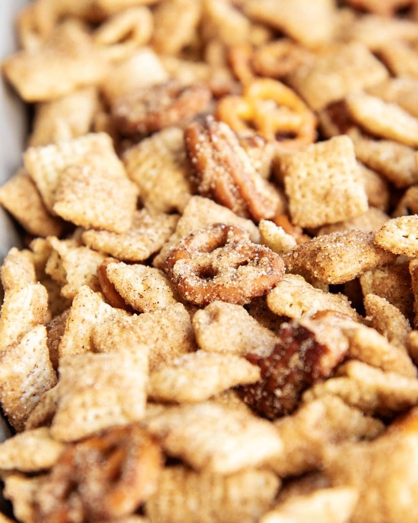 A close up of cinnamon sugar chex mix on a baking pan.