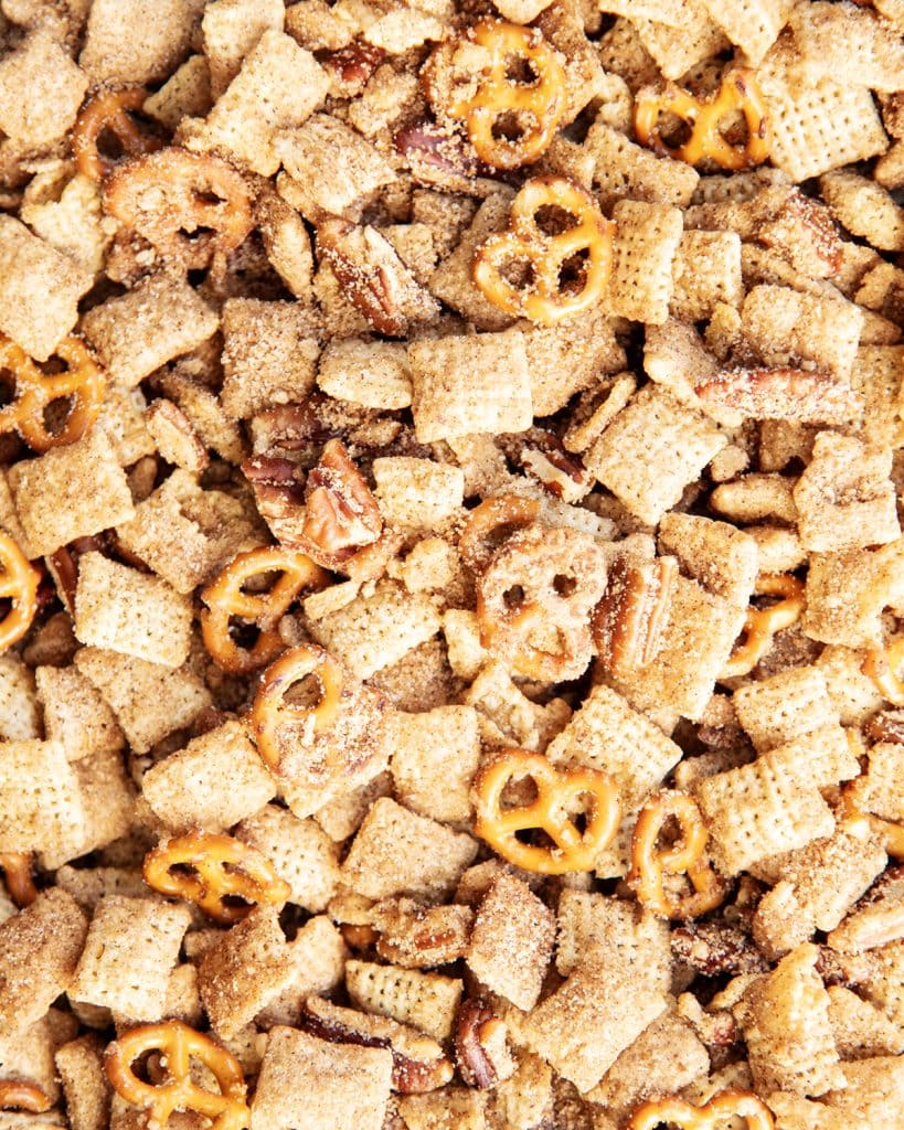 Churro chex mix with chex cereal, mini pretzels, and pecans all coated in a cinnamon sugar mixture.