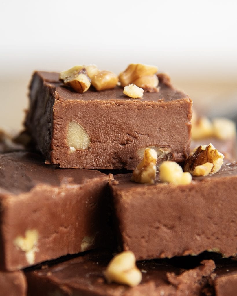 A close up of a pile of Chocolate Walnut fudge topped with more walnut pieces.