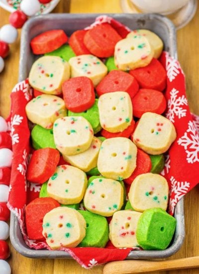 A pan of mini Christmas shortbread cookies. They are Christmas colored, red, white, and green.