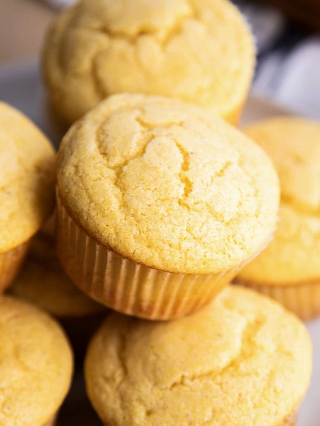 A pile of cornbread muffins on a plate.