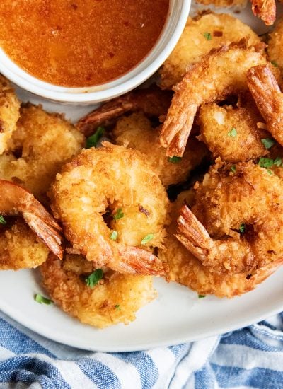 A pile of coconut shrimp topped with flakes of fresh cilantro.