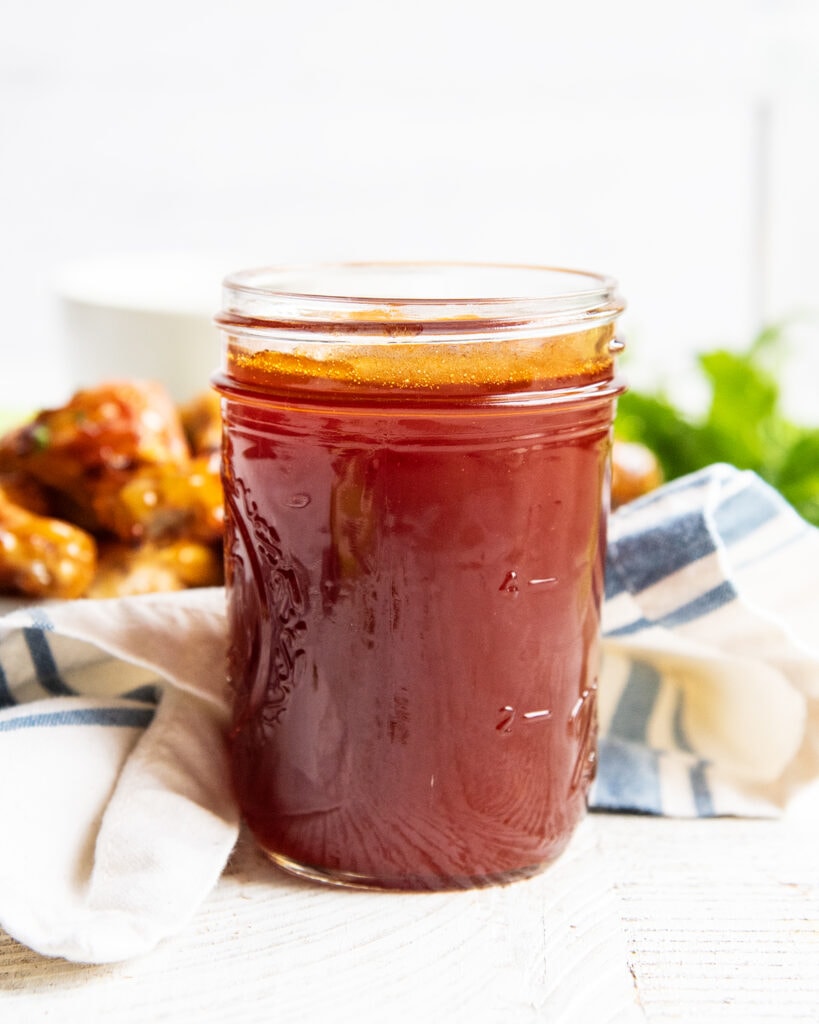 A side shot of a jar of honey buffalo wing sauce.