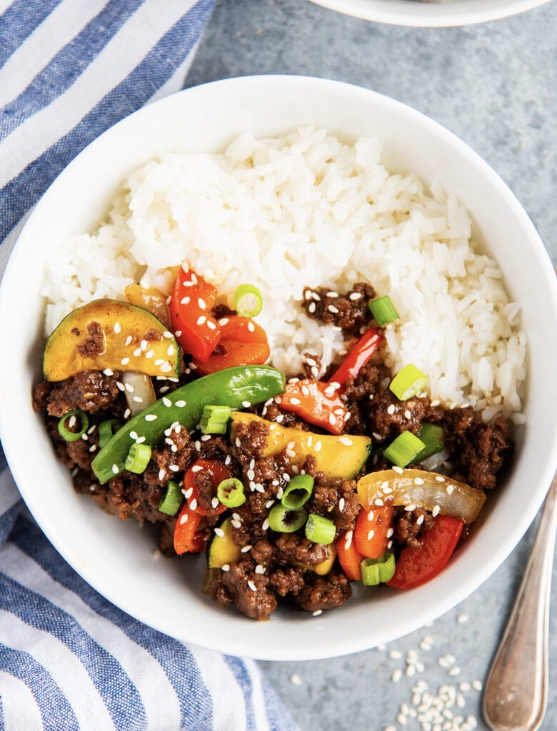 An overhead photo of a bowl of rice with Korean flavored ground beef and stir fried vegetables.