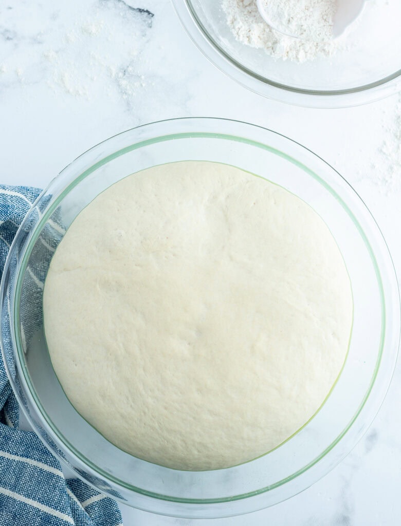 A bowl of proofed bread up to the top.