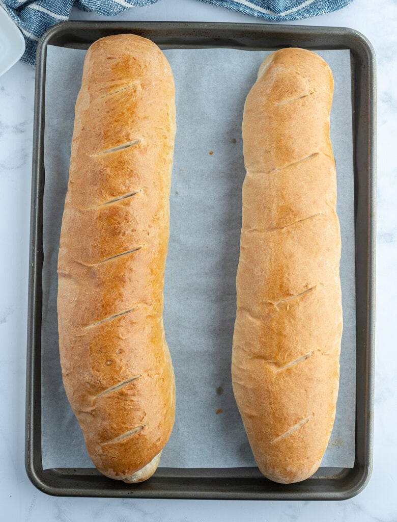 Baked french bread on a cookie sheet.