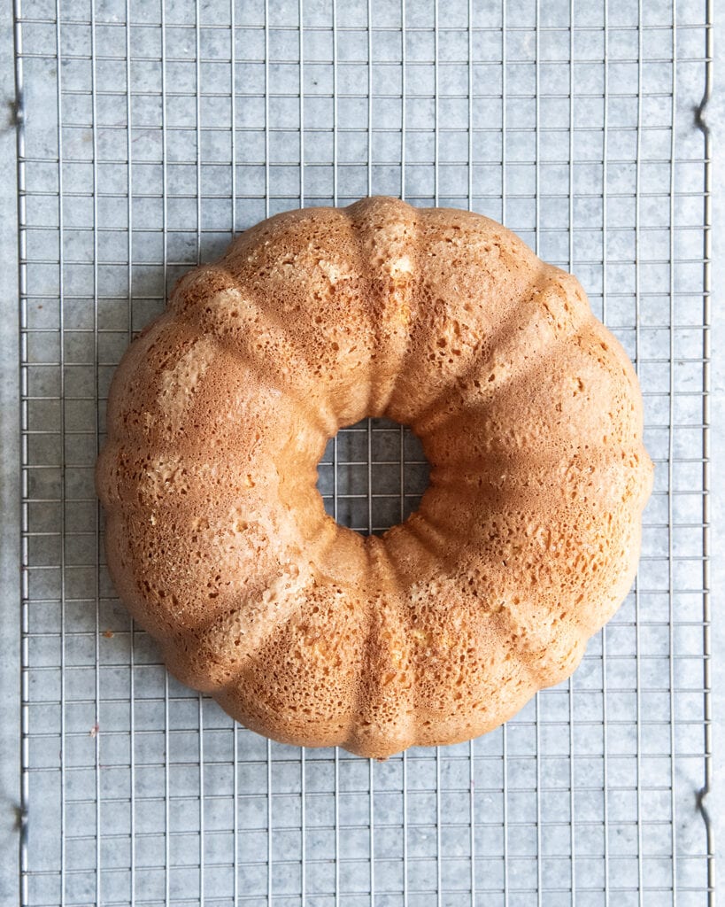 An above view of a bundt cake on a cooling rack.