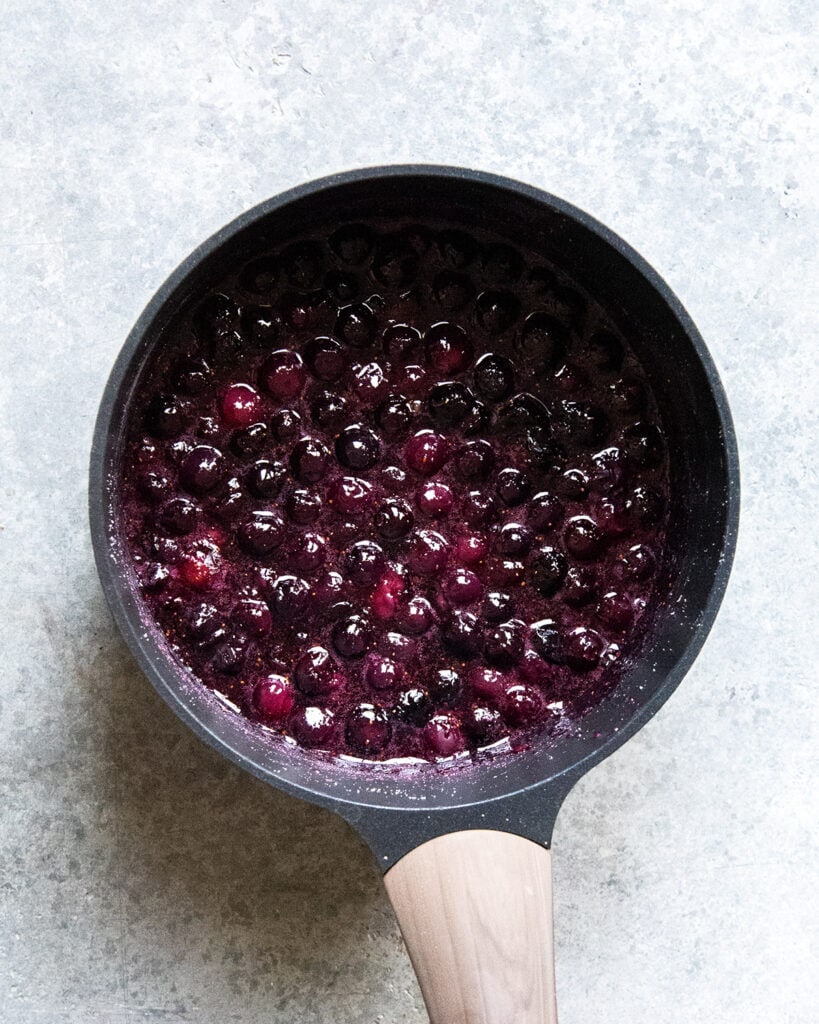 A sauce pan full of juicy blueberries.