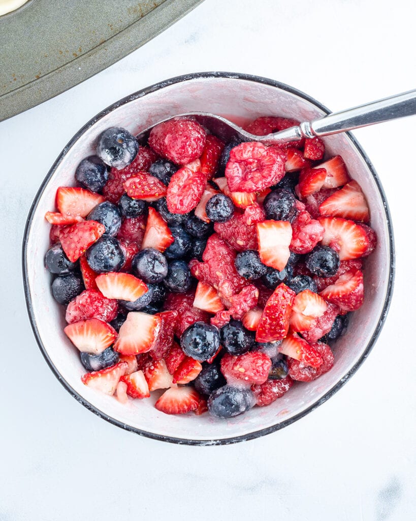 A bowl of strawberries, raspberries, and blueberries.