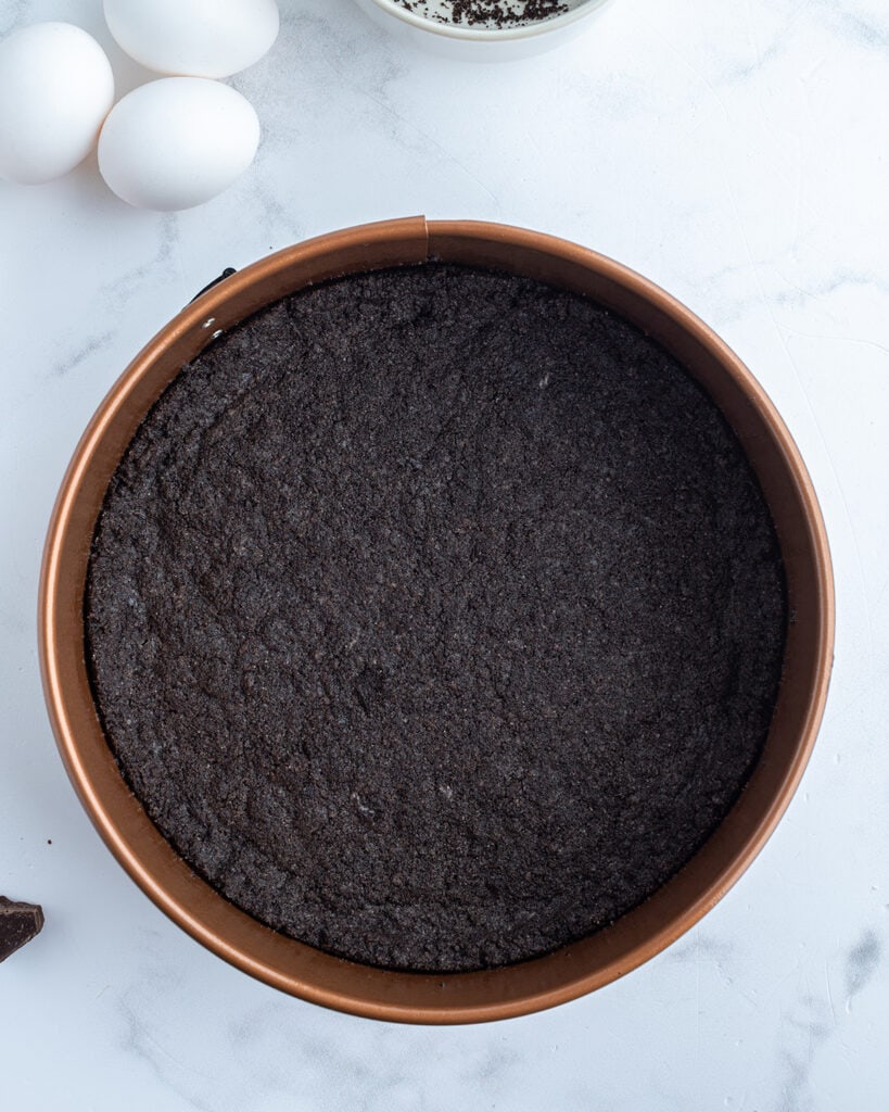 An Oreo crust in a spring form pan.