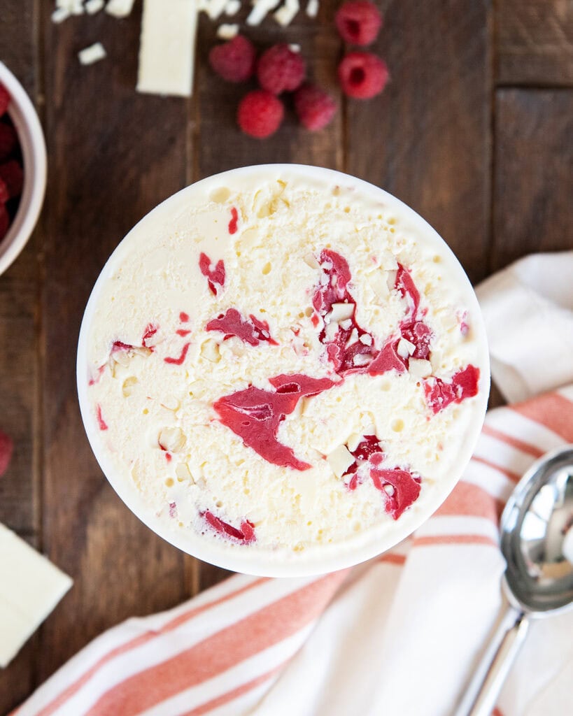 An above view of a container of white chocolate raspberry ice cream.