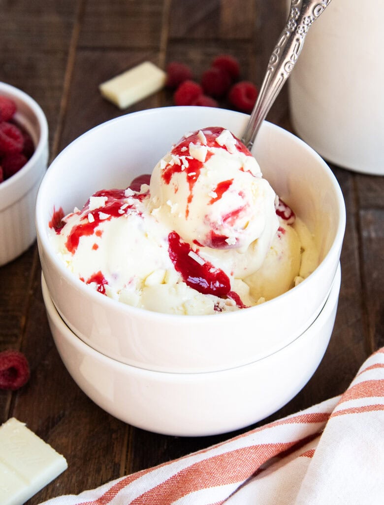 A bowl of white chocolate raspberry ice cream topped with more raspberry syrup.
