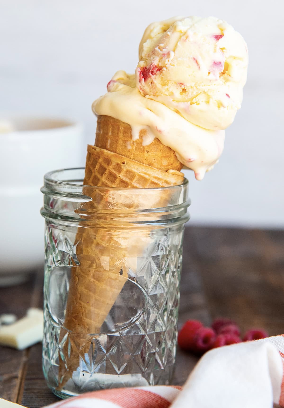 A white chocolate raspberry ice cream cone set in a glass jar.