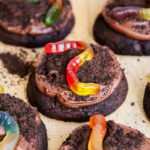 Dirt cake cookies topped with chocolate pudding frosting, oreo crumbs, and gummy worms.