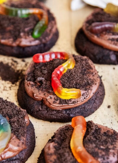 Dirt cake cookies topped with chocolate pudding frosting, oreo crumbs, and gummy worms.