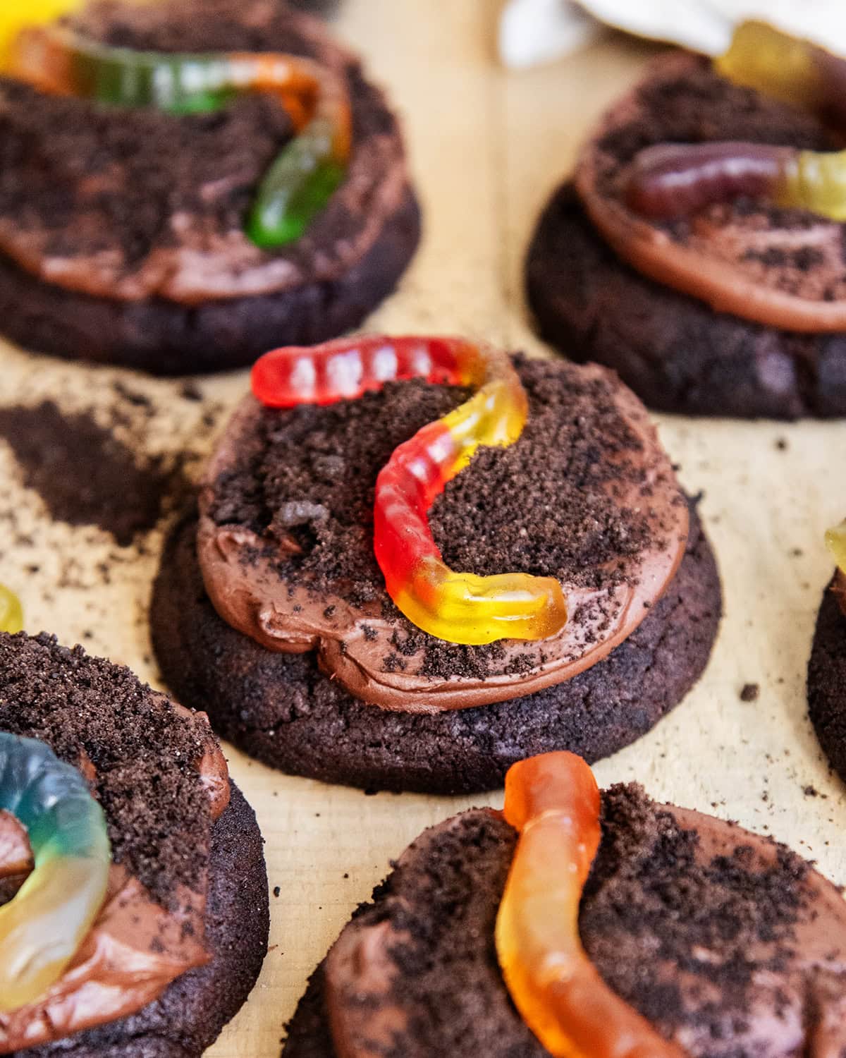 Dirt cake cookies topped with chocolate pudding frosting, oreo crumbs, and gummy worms.