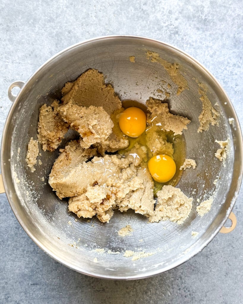 Creamed butter and sugar topped with two raw eggs in a bowl.