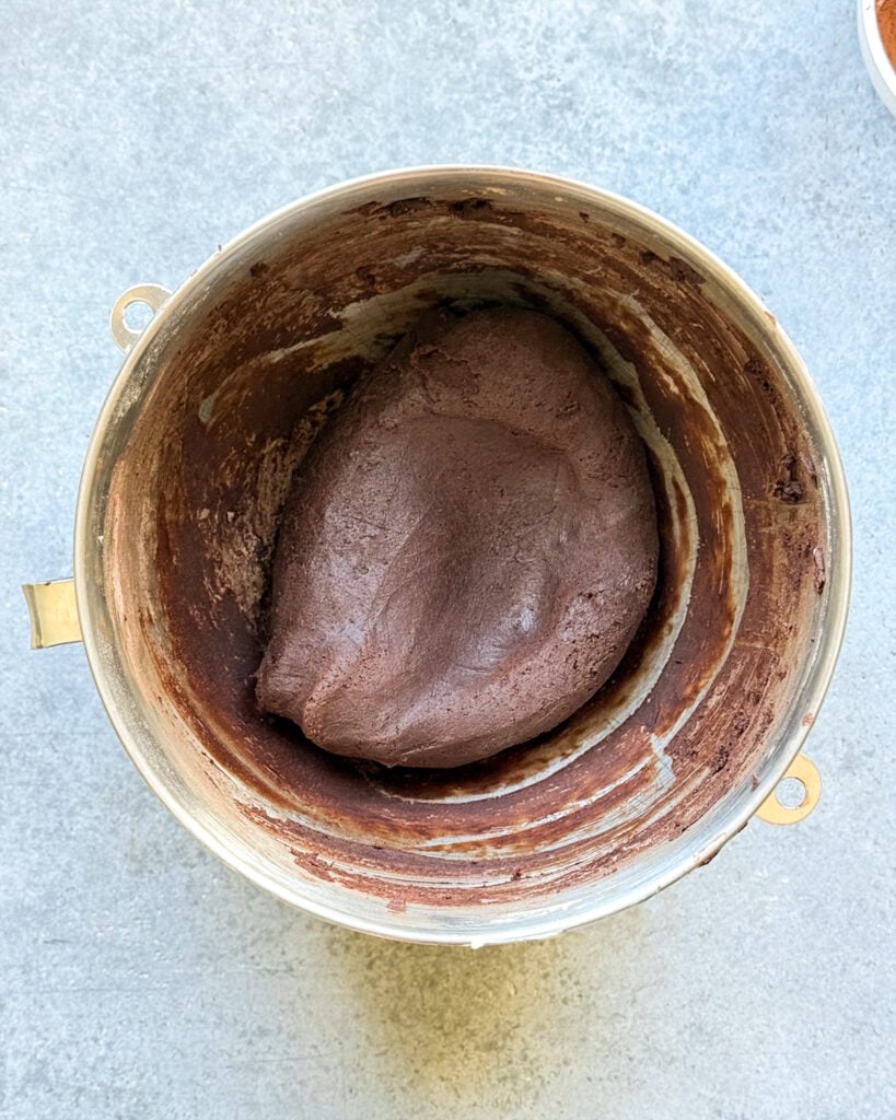 Chocolate cookie dough in a metal kitchen aid bowl.