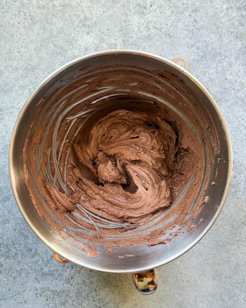 Chocolate pudding frosting in a metal bowl.