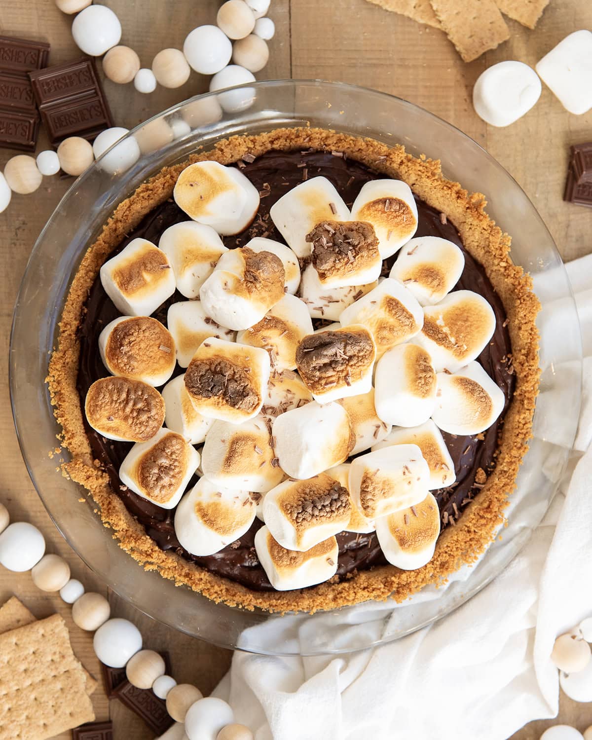 An above view of a smores pie topped with large toasted marshmallows.