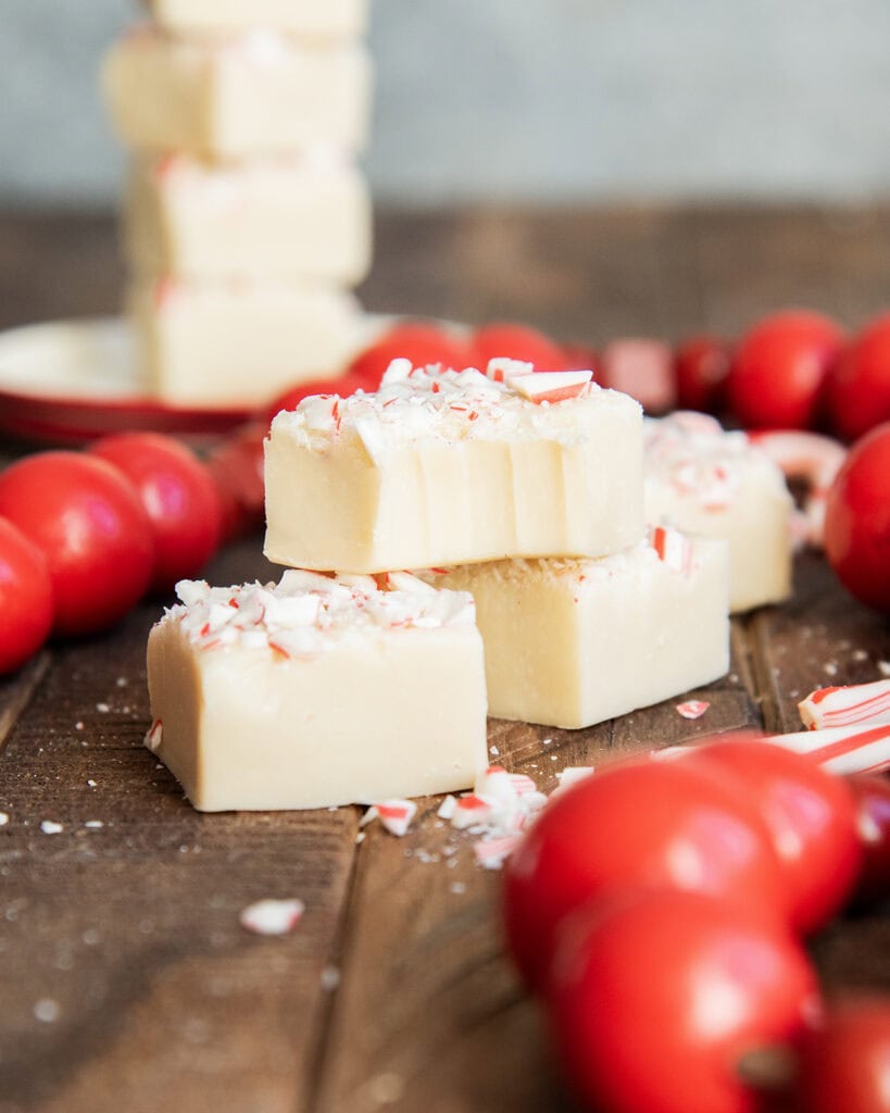 A pile of white chocolate fudge, the top piece has a bite out of it.