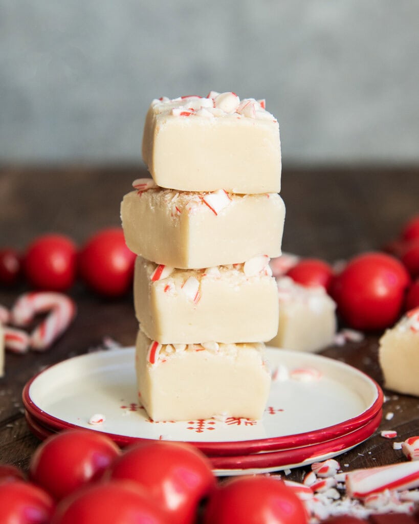 A tower of white chocolate peppermint fudge on a small plate.