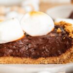 A slice of chocolate pie topped with toasted marshmallows.