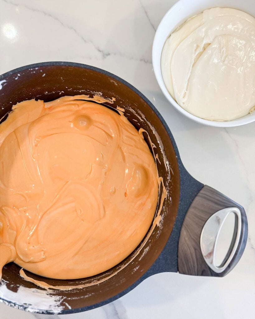 Two bowls of fudge, one is orange fudge, and one is white.