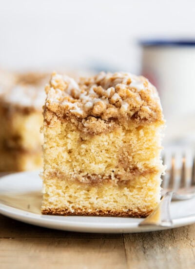 A piece of cinnamon swirl coffee cake on a plate next to a fork.